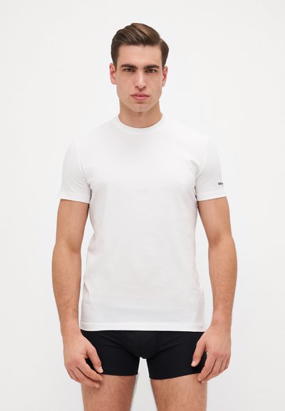 Weißes Rundhals-T-Shirt aus glattem Baumwollstoff. Kurze Ärmel und ein dezentes Logo-Detail am linken Arm. Sauberes, minimalistisches Design.