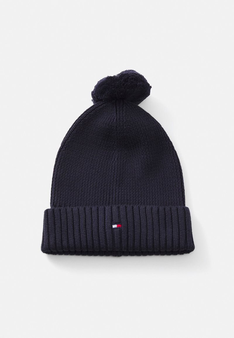 Gestickte marineblaue Mütze mit einem gerippten Bund und einem Pompon oben. Auf der Vorderseite befindet sich ein kleines Emblem in Rot, Weiß und Blau.