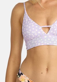 Fialový bikini top s bielym kvetinovým vzorom, trojuholníkový tvar a tenké ramienka. Obsahuje dizajn s kľúčovou dierkou v strede.