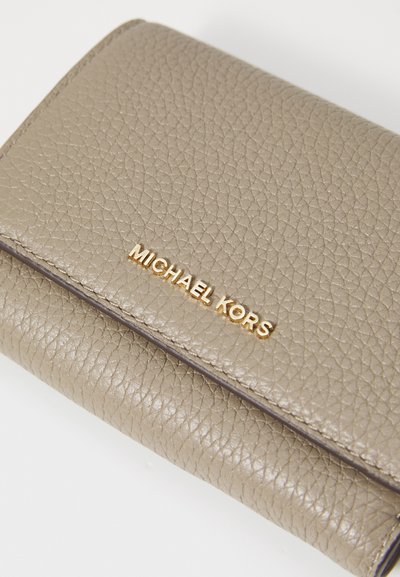 Portefeuille en cuir texturé beige avec un logo doré "MICHAEL KORS". Caractéristiques d'un design compact avec un rabat et des détails de couture.