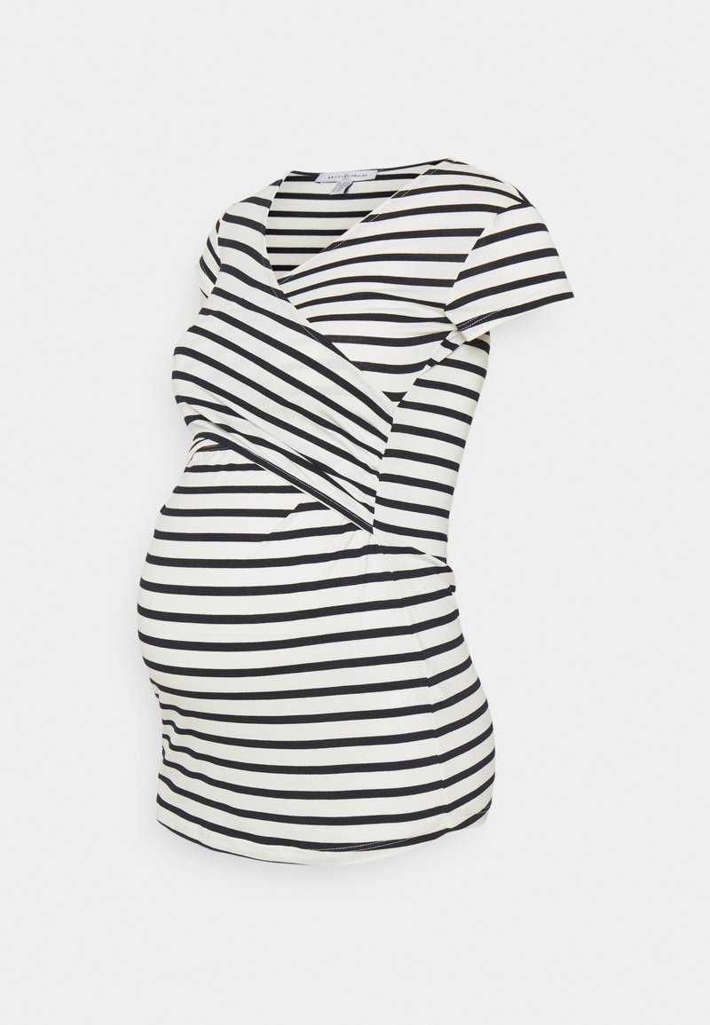 Svart och vit randig graviditetstop med omslag, korta ärmar och en åtsittande silhuett som rymmer en växande mage.