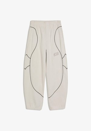 Svetlo bež trenirka s črnimi ukrivljenimi obrobami, elastičnim pasom in manšetami, stranskimi žepi ter majhnim logotipom "acs" na desni stegni.