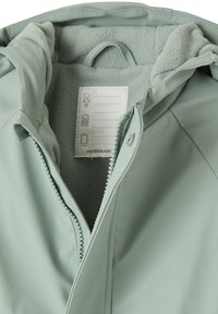 Light green waterproof jacket with fleece lining, front zipper, snap button, and label for personal information inside collar.