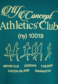 Stylizowany tekst "Concept Athletics Club (ny) 10019" z konturami sześciu biegaczy i nazwami dzielnic Nowego Jorku poniżej na zielonym materiale.