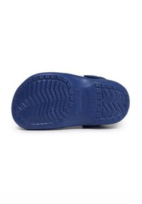 Plava gumena potplat cipele sadrži teksturirani uzorak gaznoga sloja sa cik-cak i kružnim dizajnom za bolje prianjanje. Oznake uključuju "MADE IN CHINA" i logo.