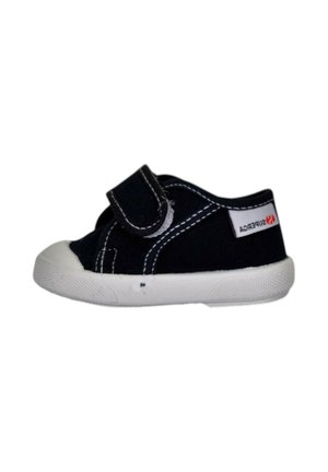 Scarpa da bambino nera con suola in gomma bianca e cinturino in velcro, con cuciture bianche e una piccola etichetta del marchio sul lato.