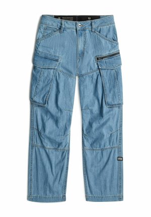 Pantalon cargo en denim bleu clair avec plusieurs poches, détail zippé sur la cuisse droite et une étiquette de marque noire près du genou gauche.