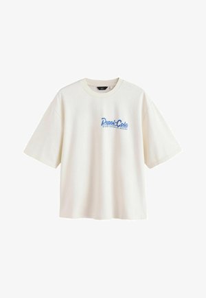 Biała koszulka z krótkim rękawem z niebieskim nadrukiem tekstu "Pepsi-Cola Diner Open 24 Hours" na lewej stronie klatki piersiowej.