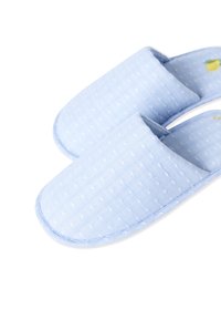 Pantofole in tessuto azzurro chiaro con un sottile motivo a pois, forma arrotondata e apertura sul retro per una facile indossabilità. Superficie testurizzata e cuciture morbide.