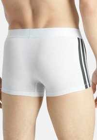 Weiße Baumwoll-Boxershorts mit glatter Textur, versehen mit schwarzen vertikalen Streifen an den Seiten und einem weichen elastischen Bund.