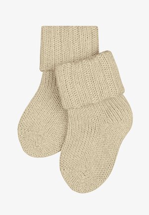 Chaussettes en tricot beige avec un revers replié, présentant un motif texturé et un bout arrondi. Le matériau semble doux et extensible pour le confort.