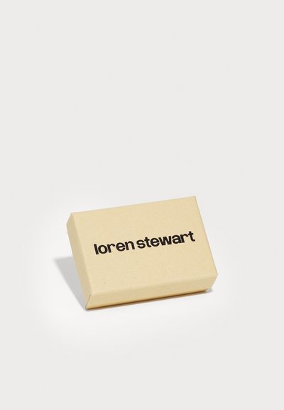 Caja de cartón marrón con una textura suave que presenta "loren stewart" impreso en negrita con fuente negra en el frente.