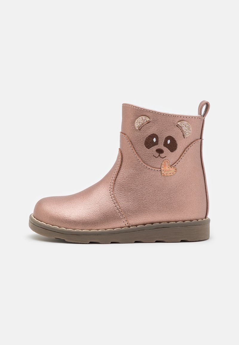 Botte enfantine rose métallisée avec semelle marron, décorée d'un visage d'ours souriant et d'oreilles scintillantes sur le côté.