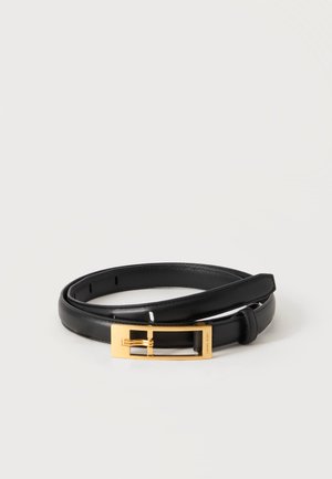 Ceinture en cuir noir roulée avec une boucle rectangulaire en métal doré sur un fond clair uni.