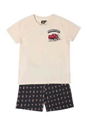 Camiseta beige de manga corta con gráfico de Rayo McQueen y pantalones cortos negros con estampado de llamas rojas y blancas e íconos de trofeos.