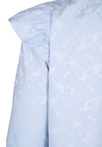Helles blaues Material mit einem strukturierten Blumenmuster. Verfügt über gepuffte Schulterakzente. Glatte, gewebte Oberfläche mit subtiler Schattierung.