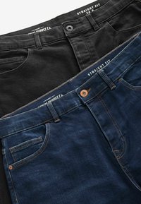 Twee paar recht gesneden jeans: één zwart, één donkerblauw. Beide hebben voorzakken, contrasterende stiksels en metalen knopen aan de taille.