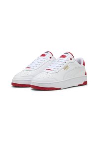 Hvide sneakers med røde accenter. Glat syntetisk materiale, perforeret tåboks og tykkere hvid sål. Gyldent logo på siden.