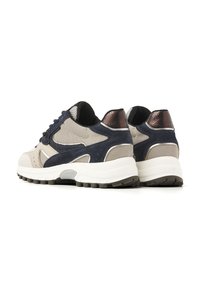 Sneakers mit einem beigen Mesh-Obermaterial, marineblauen Wildlederelementen und metallischen Akzenten. Weiße Zwischensohle, strukturierte dunkle Außensohle und Schnürdesign.