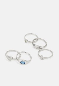 Conjunto de cinco anillos de plata con diseños variados: forma de corazón, piedra azul, acento verde, superficies texturizadas y acabados suaves.