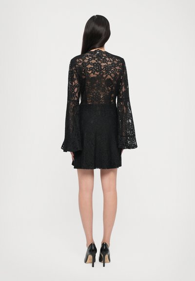 Black lace dress with a bell-sleeve design, featuring a sheer back and a layered skirt. Worn with black high-heeled shoes.