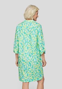 Minzgrünes Kleid mit einem Blättermuster, 3/4-Ärmeln und einem Knopfdetail an den Ärmelbündchen. Weicher Stoff mit lockerer Passform.