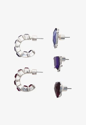 Zwei Paar Ohrringe mit lila und roten facettierten Steinen. Ein Paar hat ein geschwungenes Design mit einem metallischen Finish, und das andere hat eine geometrische Form.