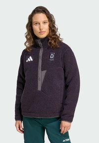 Giacca in pile viola con collo alto, con dettagli grigi, bottoni a pressione e loghi TEAM e Olimpico sul petto.