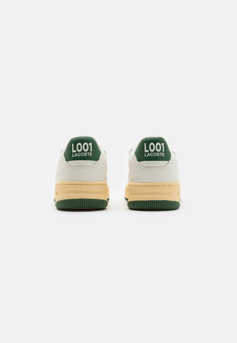 Baskets en cuir blanc avec des onglets de talon verts et le texte "L001 LACOSTE". Semelle intermédiaire jaune et semelle extérieure en caoutchouc verte. Forme arrondie, design minimal.