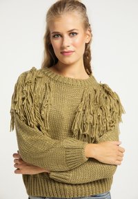 Olijfgroen gebreide trui met franjes op de schouders, textuur ribbelsteek en lange mouwen. Een casual ontwerp met een ronde halslijn.