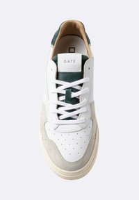 Witte sneaker met beige su�ède accenten, geperforeerde teen, groene tong en hak, witte veters en "D.A.T.E." branding op de tong.