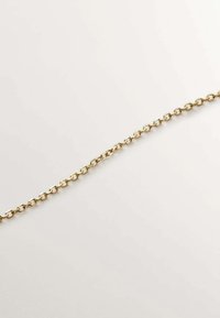 Cadena de oro con eslabones ovalados, textura suave y un acabado brillante. Los eslabones están entrelazados, creando un diseño ligero y flexible.