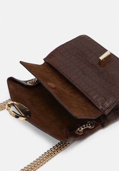 Rudas krokodilo rašto od sintetinės odos rankinė su zomšo interjeru. Yra auksinė metalinė saga ir ilga auksinė grandinėlė. Atidarius matyti vidus.