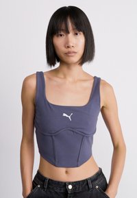 Korte sporttop in marineblauw, gemaakt van rekbare stof, met een wit Puma-logo, vierkante halslijn en een slim-fit ontwerp.