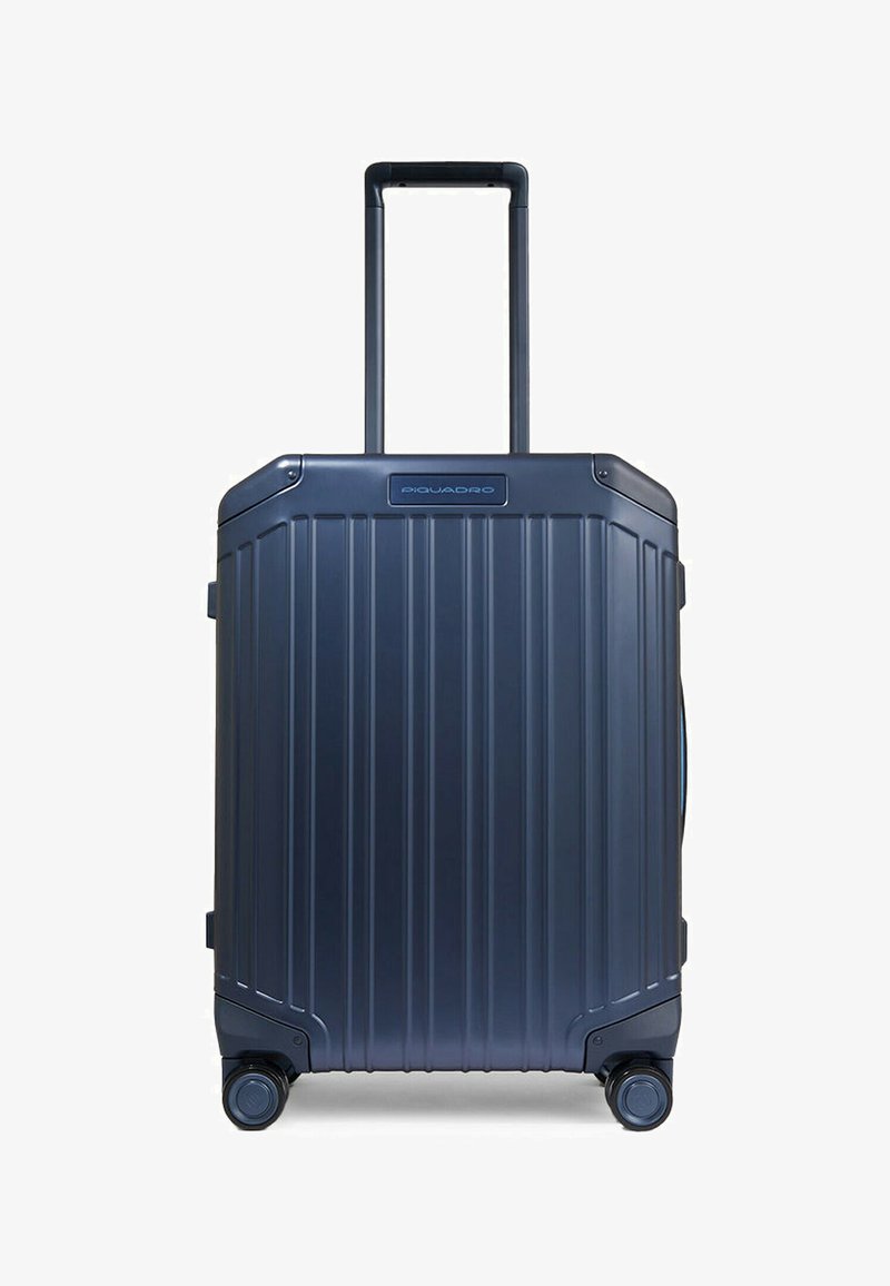 Hartschalenkoffer in Dunkelblau mit vertikalen Rippen, ausziehbarem Griff und vier Rollen für einfache Mobilität. Piquadro-Logo auf der Vorderseite.