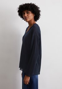 Top a maniche lunghe blu navy in tessuto leggero, con scollatura a V e vestibilità comoda, caratterizzato da una texture leggermente trasparente.