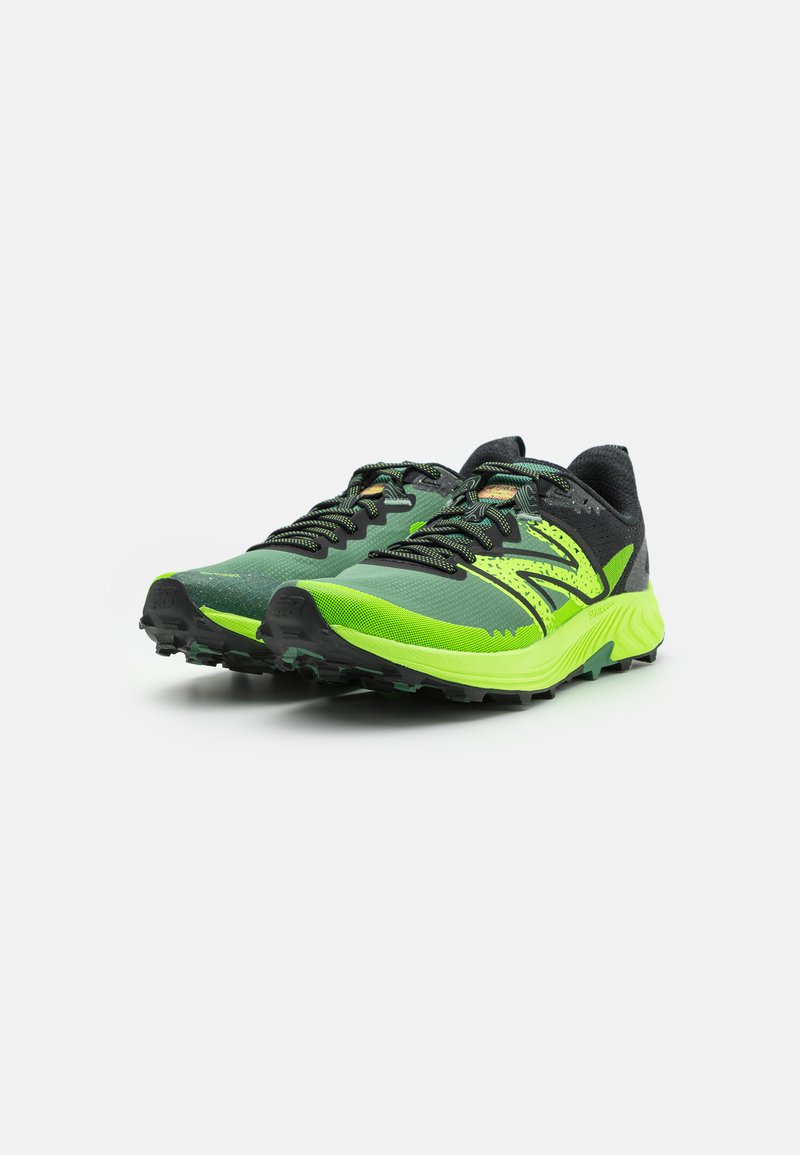 Zapatillas de trail running en verde y negro con parte superior de malla texturizada, puntera reforzada y suela con un diseño agresivo para mayor tracción.