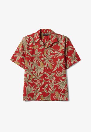 Chemise rouge à manches courtes avec boutons, motif feuilles et fleurs tropicales beige et jaune, col à revers et étiquette de la marque Piombo à l’intérieur du col.