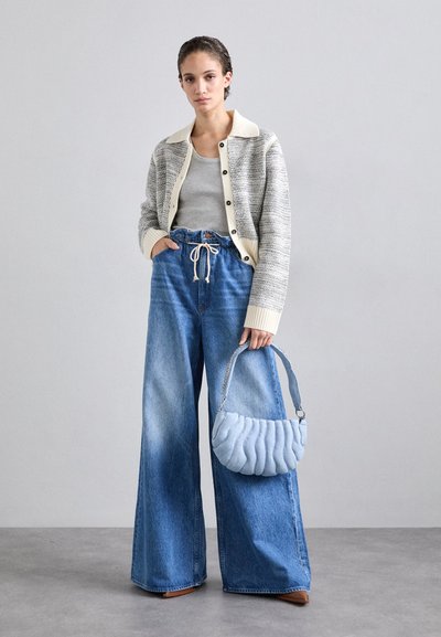Strikket cardigan med cremet krave, grå top, højhalset brede jeans og lyseblå foret taske med kædestrop.