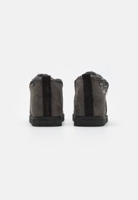 Grijze suède enkellaarsjes met een gestructureerde afwerking, voorzien van zwarte stofstroken en een zachte binnenvoering. Rubber zolen voor grip.