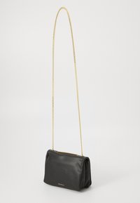 Black leather handbag with a structured shape, featuring a gold chain strap and subtle logo detail on the front. Smooth texture.
