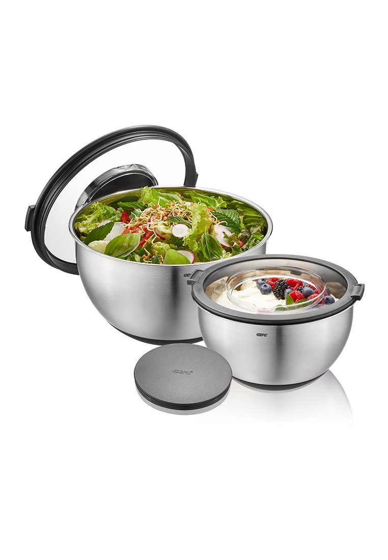 Bławowka stalowa do sałatek z czarnym uchwytem, wypełniona mieszanką sałat. Zawiera mniejszą miseczkę na deser z owocami jagodowymi i czarną pokrywką.