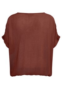 T-shirt oversize couleur rouille avec une coupe ample, des manches courtes et un tissu léger texturé. L'ourlet est légèrement arrondi et brut.