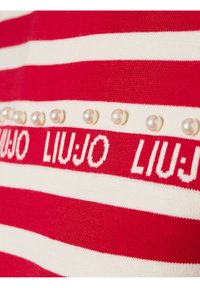 Rood en wit gestreepte gebreide stof met de merknaam "LIU JO" in een herhalend patroon, versierd met decoratieve parelachtige kralen.