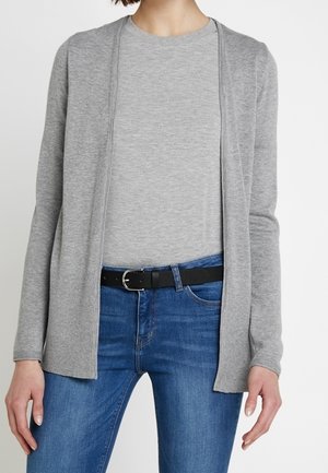 Grauer langer Cardigan aus weichem Strickstoff, offenes Design, kombiniert mit einem grauen Top und blauen Jeans. Schwarzer Gürtel in der Taille.