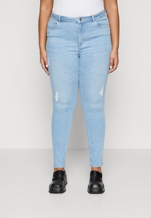 Light blue skinny jeans with distressed rips and a high waist, paired with black platform shoes. Fabric is denim with a smooth texture.