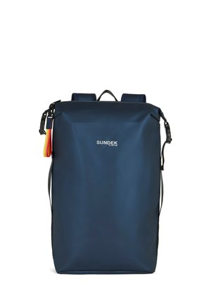 Zaino rettangolare blu navy con spallacci neri, una piccola maniglia e un anello di tessuto rosso-giallo sul lato, etichettato "SUNDEK."