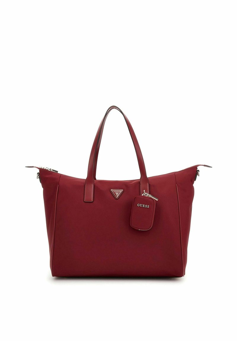 Sac fourre-tout rouge en matériau synthétique lisse. Dispose de doubles poignées, d'un logo triangulaire et d'une petite étiquette rectangulaire. Fermeture zippée.