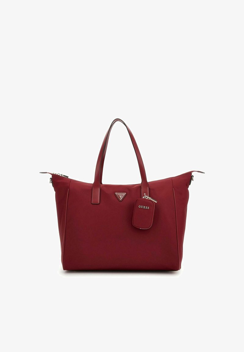 Sac fourre-tout rouge en matériau synthétique lisse. Dispose de doubles poignées, d'un logo triangulaire et d'une petite étiquette rectangulaire. Fermeture zippée.