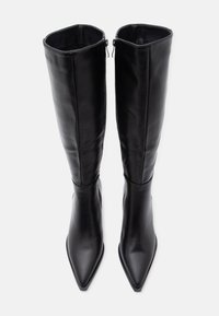 Bottes noires en cuir montant jusqu'au genou, à bouts pointus, texture lisse et fermetures éclair latérales. Présentent une silhouette ajustée et un design épuré.